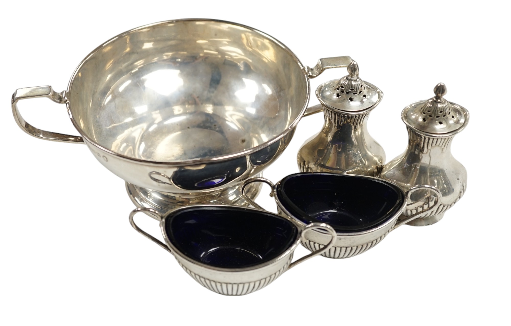 A George V silver two handled bowl and two pairs of early 20th century silver condiments. Condition - poor to fair